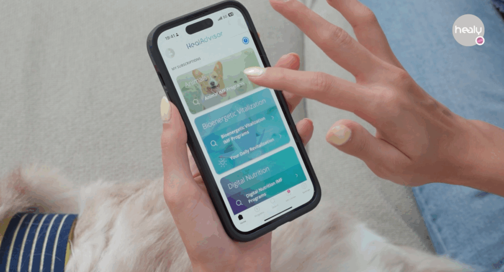 한 손에 스마트폰을 들고 힐리디바이스 힐리 애니멀 모듈 앱을 열고 다른 기능을 드래그 하고 있습니다.